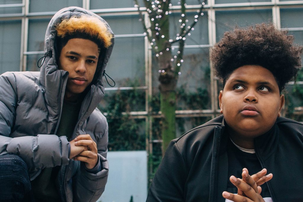 Promotional photograph of AJ x Deno.